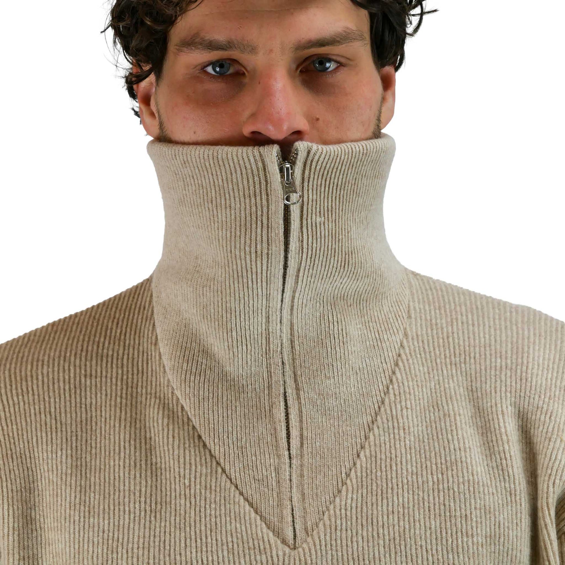 Herr trägt natur-farbenen Boragno Troyer-Pullover aus Lambswool mit halbem Reißverschluss und hohem Kragen.